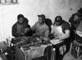 Chinese cobblers working on shoes. In the CBI during WWII.   Photo by Syd Greenberg.