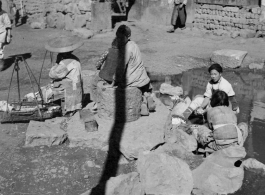 Chinese women washing either cotton or silk cocoons during WWII, in a village in China, probably in Yunnan province.  From the collection of Wozniak, combat photographer for the 491st Bomb Squadron, in the CBI.