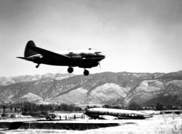 A C-46 lands in Yunnan province, flying in over the carcass of another C-46.