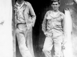 "Elmer Bukey and Chester Rush in the doorway of our engineering office at Liangshan,China. The holes and the damage seen are the results of nightly air raids by the Japanese. Our engineering area left a lot to be desired but it was amazing the amount of and the quality of the work that was performed by the men."