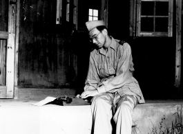 A GI typing on a small typewriter in the China during WWII.