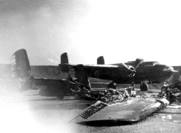 In the foreground of this revetment are the remains of a North American B-25 bomber, like the one in the background, after it burnt up. This was possibly due to a night attack by Japanese bombers.