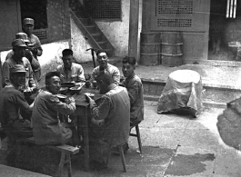 Chinese soldiers take a meal during WWII in the courtyard of a home, in Yunnan province, China, most likely around the Luliang air base area.