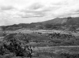 Scenery in China.  Note the young man in work coveralls and holding a carbine in the foreground.  This is probably near Yangkai, Yunnan.