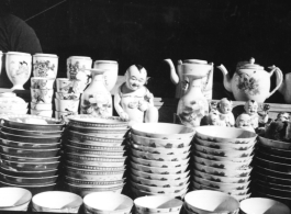 Decorative china cups, tea pots, and figurines in a china shop in China during WWII.