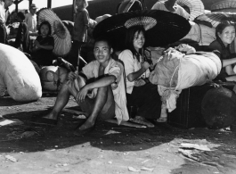 Chinese refugees shelter from the hot sun under paper umbrellas at the train station in Liuzhou during WWII, in the fall of 1944, as the Japanese advanced during the Ichigo campaign.