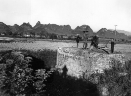 Chinese civilians looking over a bridge destroyed near Liuzhou before the Japanese advance in the fall of 1944.