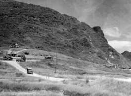 A jeep comes down from a cluster of tents and workshops at Liuzhou during WWII, in 1945.