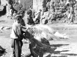 Villages threshing rice in the first village, on way to Yangkai, China 1944. During WWII.