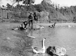 Villagers do the chores on shore of village pond. Probably near Yangkai, 1945.  From the collection of Frank Bates.