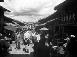 Local scenes and local people in Yunnan province, China, most likely around the Luliang air base area.  A local street in a village or town near the American air base. The sign on the building on the right advertises a tea house 天天有茶社.