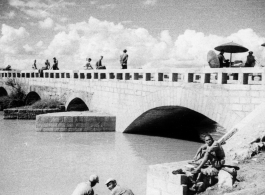 Nationalist soldiers (plus possibly one GI) lounge on the bridge at Luliang. During WWII.