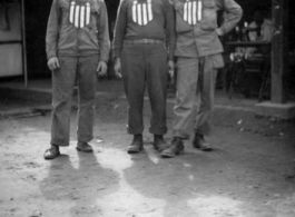 GIs with banners stuck to their chests, apparently purchased from the shop immediately behind them. In India during WWII.