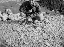 Probably a local boy in China, holding a small animal. During WWII.