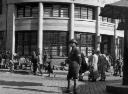 Scenes around Kunming city, Yunnan province, China, during WWII: Street corner with a stern traffic cop and the "Kunming Commercial Bank, Ltd."