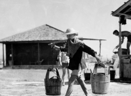 Laborer at an American air base carrying pails--they may not have smelled nice--in the CBI.