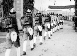 Burma Road dedication parade and ceremony in Kunming, China, on or around February 4, 1945, during WWII. Review of first convoy (or one of the first convoys) to reach China. Chinese soldiers marching in fancy parade dress taking part in elaborate parade.