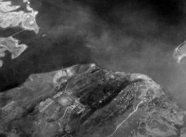 Aerial view of a large organized campus with large ornate buildings, an athletic track, housing, etc., in either SW China, Burma, or French Indochina, in the CBI, during WWII. Is this a university of some kind?