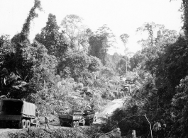 797th Engineer Forestry Company in Burma: Trucks wait for work on section of corduroy road over muddy patch on the Burma Road.  During WWII.