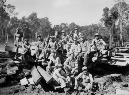 Engineers of the 797th Engineer Forestry Company pose outside on pile of sawn lumber at a camp in Burma.  During WWII.