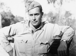 Engineer of the 797th Engineer Forestry Company poses against truck in Burma.  During WWII.