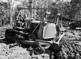 Bulldozer pushing dirt in Burma.  797th Engineer Forestry Company in Burma.  During WWII.