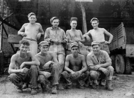 Engineers of the 797th Engineer Forestry Company pose outside truck repair garage at camp in Burma.  During WWII.