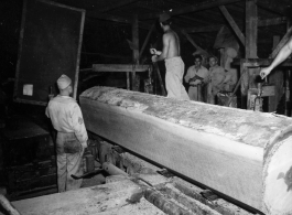 Operations of a mill of the 797th Engineer Forestry Company in Burma--a clear grain log cant on the mill.  During WWII.