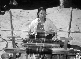 Local people in Burma near the 797th Engineer Forestry Company--A woman weaves on a loom in Burma.  During WWII.