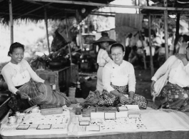 Local people in Burma near the 797th Engineer Forestry Company--ladies selling worked jewels in a market in Burma.  During WWII.