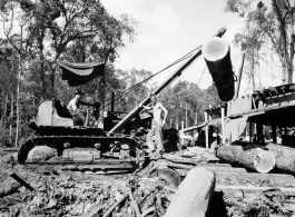 Site at the mill yard, a tracked loader feeding logs to saw line at a lumber mill of the 797th Engineer Forestry Company in Burma.  During WWII.