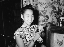 Local people in Burma near the 797th Engineer Forestry Company--a merchant girl in a fine shop in Burma. Given her clothing and economic niche, she is likely to be a member in a Chinese merchant family.  During WWII.