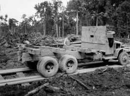 797th Engineer Forestry Company in Burma, truck backs up for loading logs for transport to sawmill for bridge building along the Burma Road.  During WWII.