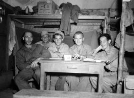 Engineers of the 797th Engineer Forestry Company pose in their barracks in Burma. Note the canned bacon on the shelf behind.  During WWII.