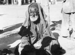 Old man begs on road in town in Burma or India.  Near the 797th Engineer Forestry Company.  During WWII.