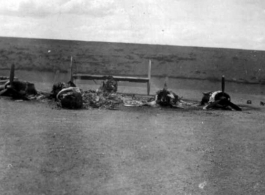 "What One Small Fragmentation Bomb Could Do--This B-24 was hit with one small fragmentation bomb during one of the nightly air raids at Luichow [Liuzhou], China.This particular plane just happened to be a new B-24 that had never flown a mission. As bad as it looks it was not a total loss since the engines were removed, inspected and run-outs done on the crankshafts to be sure they were not damaged. All the engines were used to replace blown engines on the B-24's that were flying gas into China from India. T