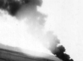 An American airplane burning in the distance after a Japanese air raid. In China, during WWII.