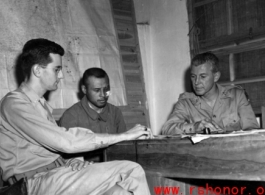 Officers--including possibly a Chinese translator--meet at a base in China during WWII.