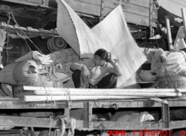 Chinese refugee waits atop flatbed car at the train station in Liuzhou during WWII, in the fall of 1944, as the Japanese advanced during the Ichigo campaign.