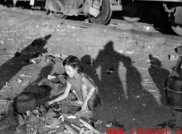 Chinese refugee--a young girl in this case--tends a cooking fire to boil water next to the train tracks in Liuzhou during WWII, in the fall of 1944, as the Japanese advanced during the Ichigo campaign.