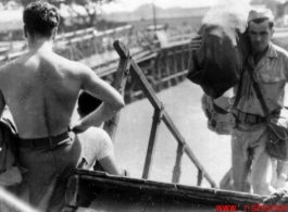 GIs board ship on the way back to the US after the war. The ship is probably the SS Marine Raven.