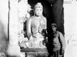 GI poses with Buddhist statuette in the CBI during WWII.