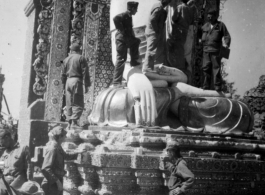 GIs examine Burmese Buddha statue in destroyed temple. During WWII.