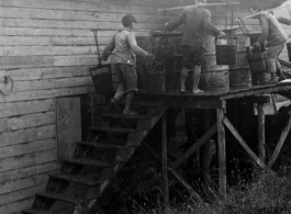 Laborers filling water cistern (of 55-gallon drums) at an American base in SW China during WWII.