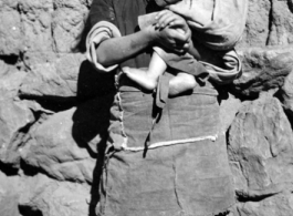 A girl holds a child. Local people in China, probably in Yunnan province.  From the collection of Wozniak, combat photographer for the 491st Bomb Squadron, in the CBI.