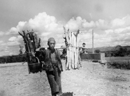 Man shouldering firewood in Yunnan during WWII.