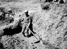 Scenes around Kunming city, Yunnan province, China, during WWII: A Chinese conscript works mud, probably for adobe brick or fired brick making. 