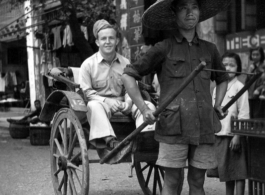 Scenes around Kunming city, Yunnan province, China, during WWII: Rickshaw puller and GI pose for a picture.