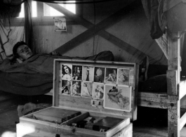 Barracks life at an American base in southwest China during WWII: Bunk, chest, and pin-ups.