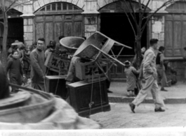 Chinese man carrying furniture in street of Kunming. March 1945.